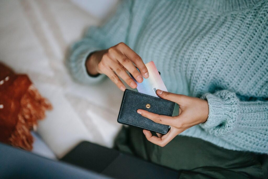 Crop unrecognizable woman taking credit card out of wallet