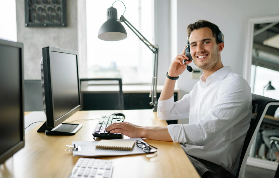 Man in White Long Sleeve Shirt Sitting in Front of a Computer
